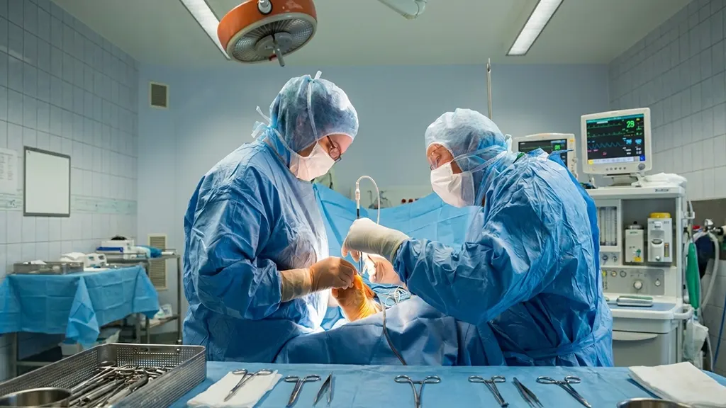 Chirurgien orthopédiste en tenue stérile préparant une intervention percutanée mini-invasive sur un pied dans une salle d'opération moderne, instrumentation spécialisée visible au premier plan