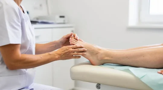 Un chirurgien orthopédiste examinant le pied d'un patient lors d'une consultation médicale